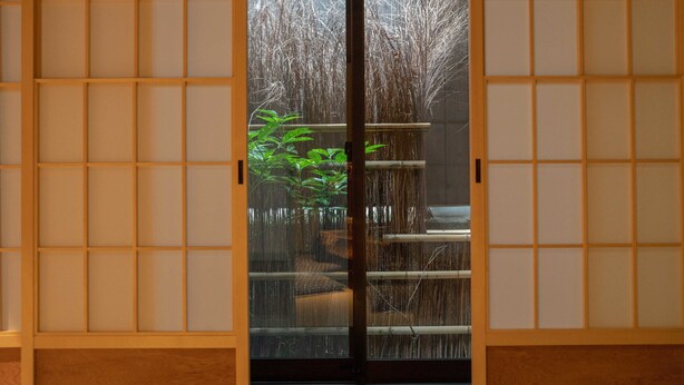A traditional Japanese room with sliding doors, a tatami mat floor, and a view of a bamboo garden. - Reikaku Kiyomizu-Gojo (Kyoto)