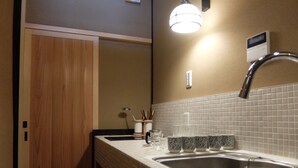 A bathroom with a sink, mirror, and wooden door. - Reikaku Kiyomizu-Gojo (Kyoto)