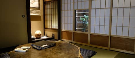 A traditional Japanese room with tatami flooring, a wooden table, and shoji screens.