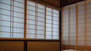 A traditional Japanese room with tatami flooring, shoji screens, and a low wooden bed. - Reikaku Kiyomizu-Gojo (Kyoto)