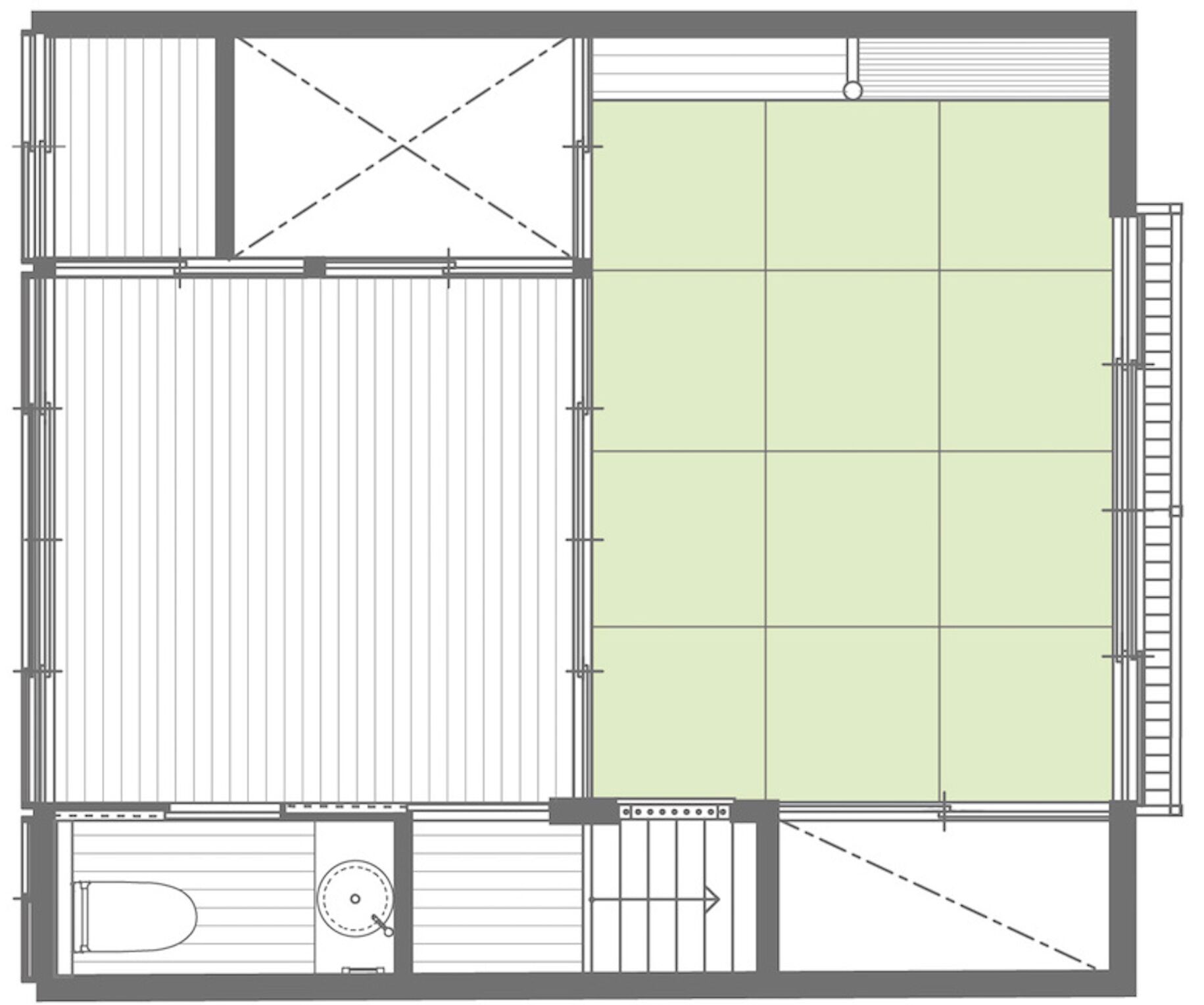 A floor plan with a large central open space, a smaller enclosed area with a toilet, and a staircase leading to an upper level.