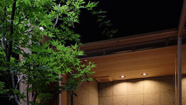 A modern bathroom with a wooden shower enclosure, tiled walls, and a small sink area. - Reikaku Yasaka (Kyoto)