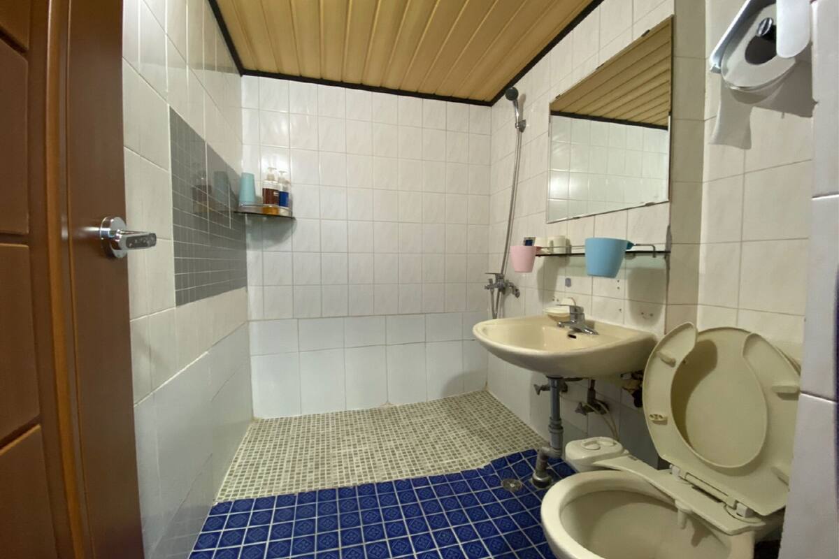 A bathroom with a toilet, sink, and shower.