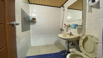A bathroom with a toilet, sink, and shower.