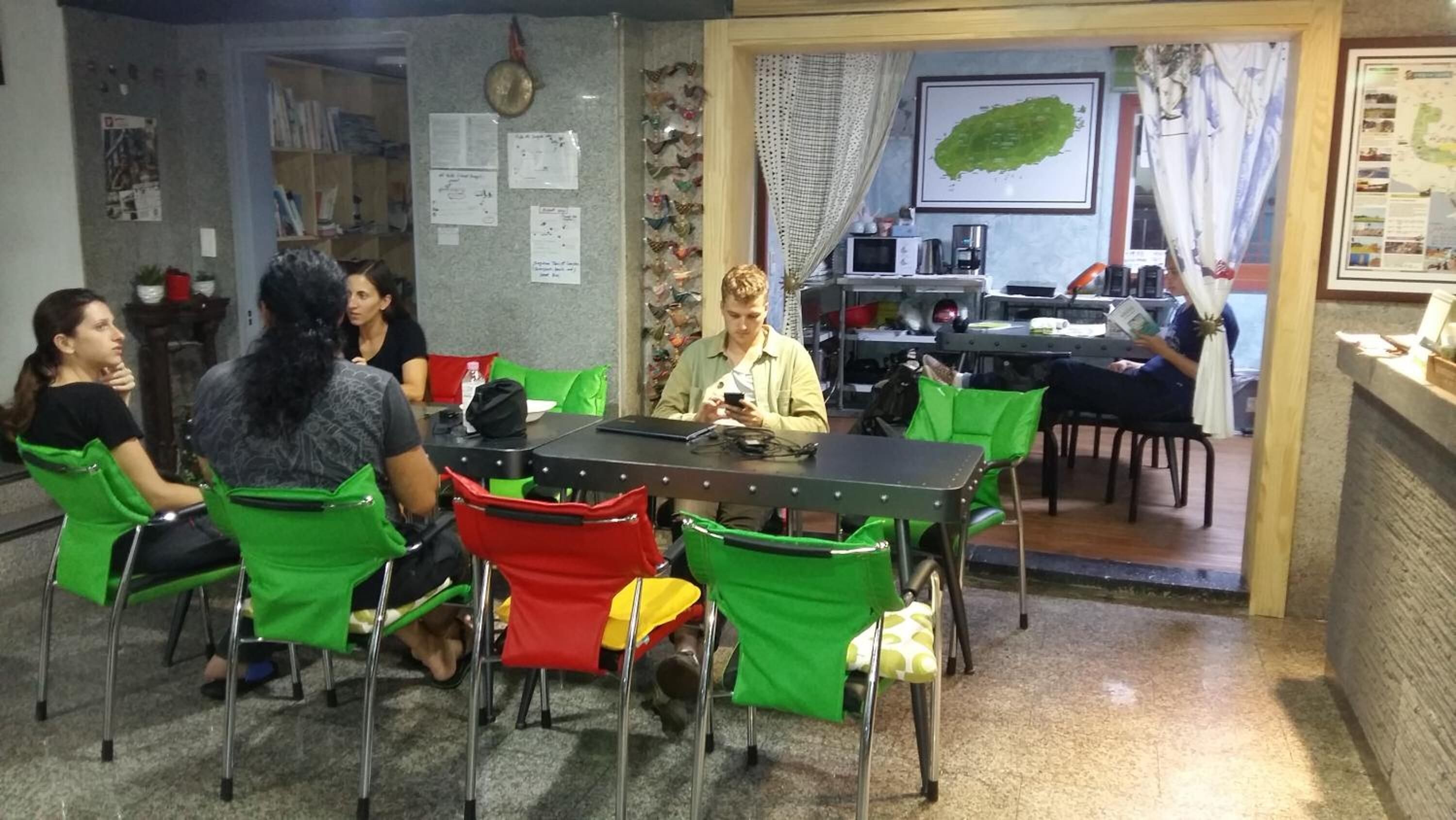 A conference room with a table and chairs, a clock on the wall, and a map on the wall.
