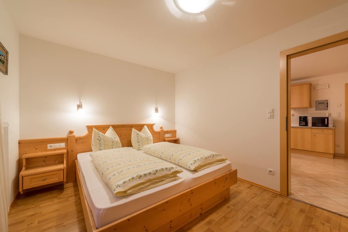 Ein Schlafzimmer mit einem Holzbett, Nachttischen und einem eingebauten Kleiderschrank.