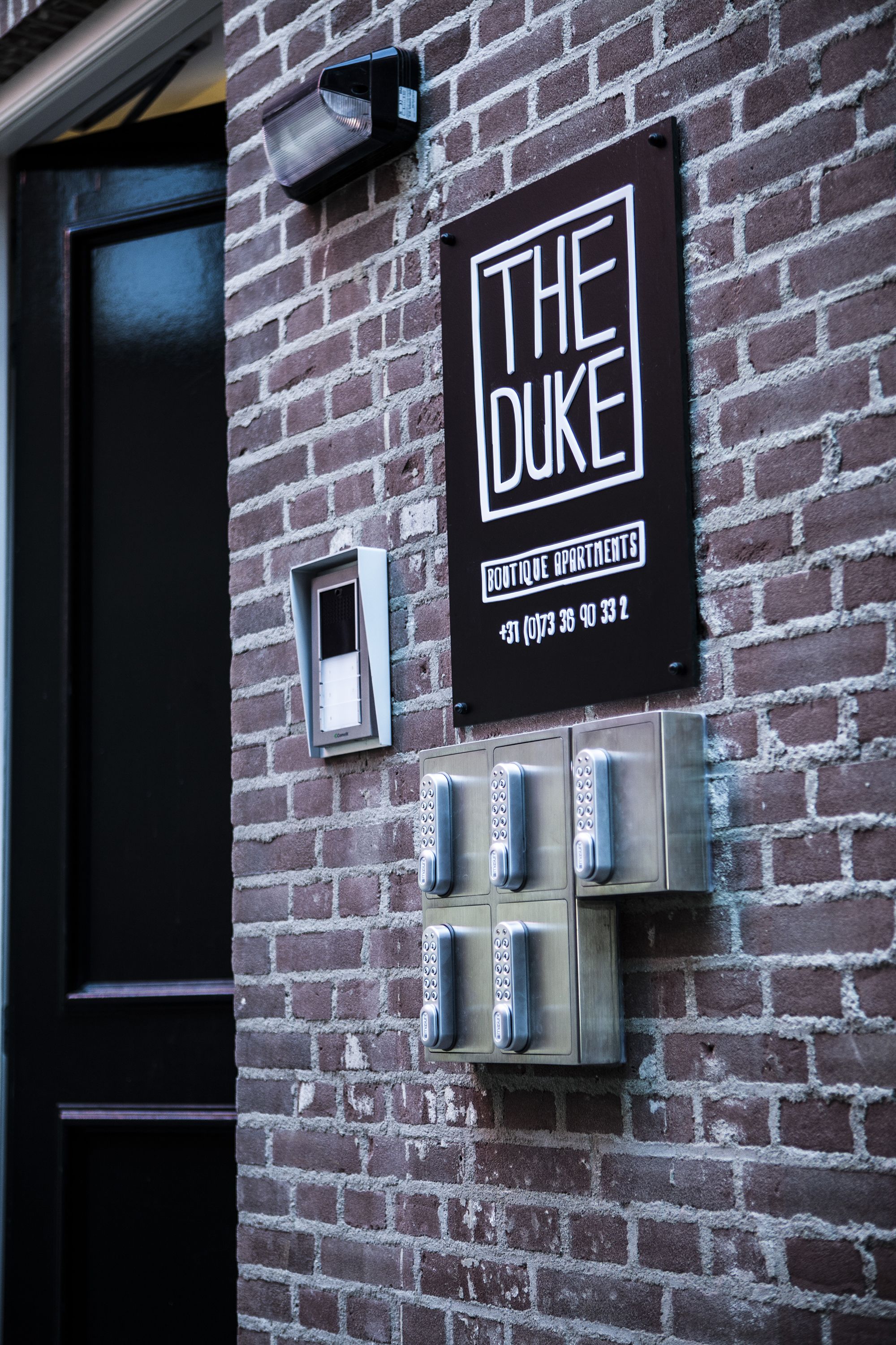A sign for "The Duke Boutique Apartments" with a contact number.