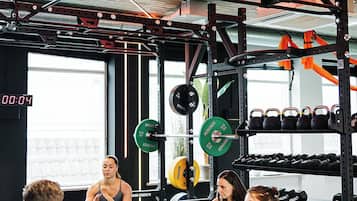 Un gimnasio con equipo de levantamiento de pesas y un temporizador digital.