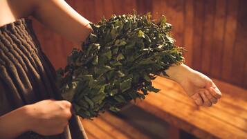 A person holding a bunch of green leaves.