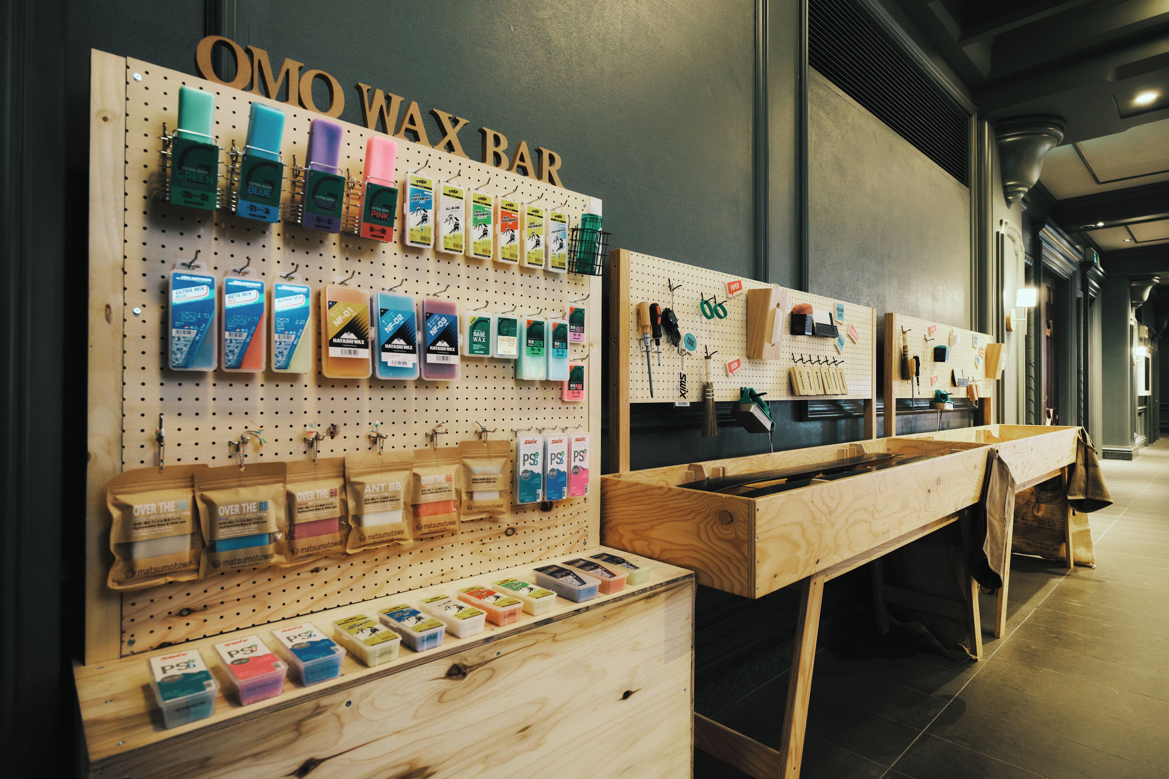 A wax bar with various wax melts and tools displayed on pegboards.