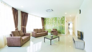A spacious living room with two sofas, a coffee table, and a television. - Hard Rock VIP Guest House (Mersing)
