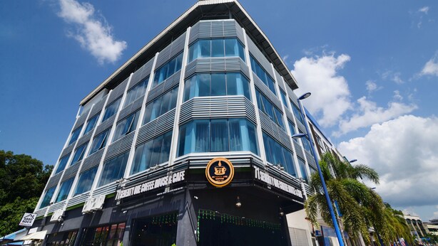 A modern building with large windows and a distinctive logo at the entrance. - Hard Rock VIP Guest House (Mersing)