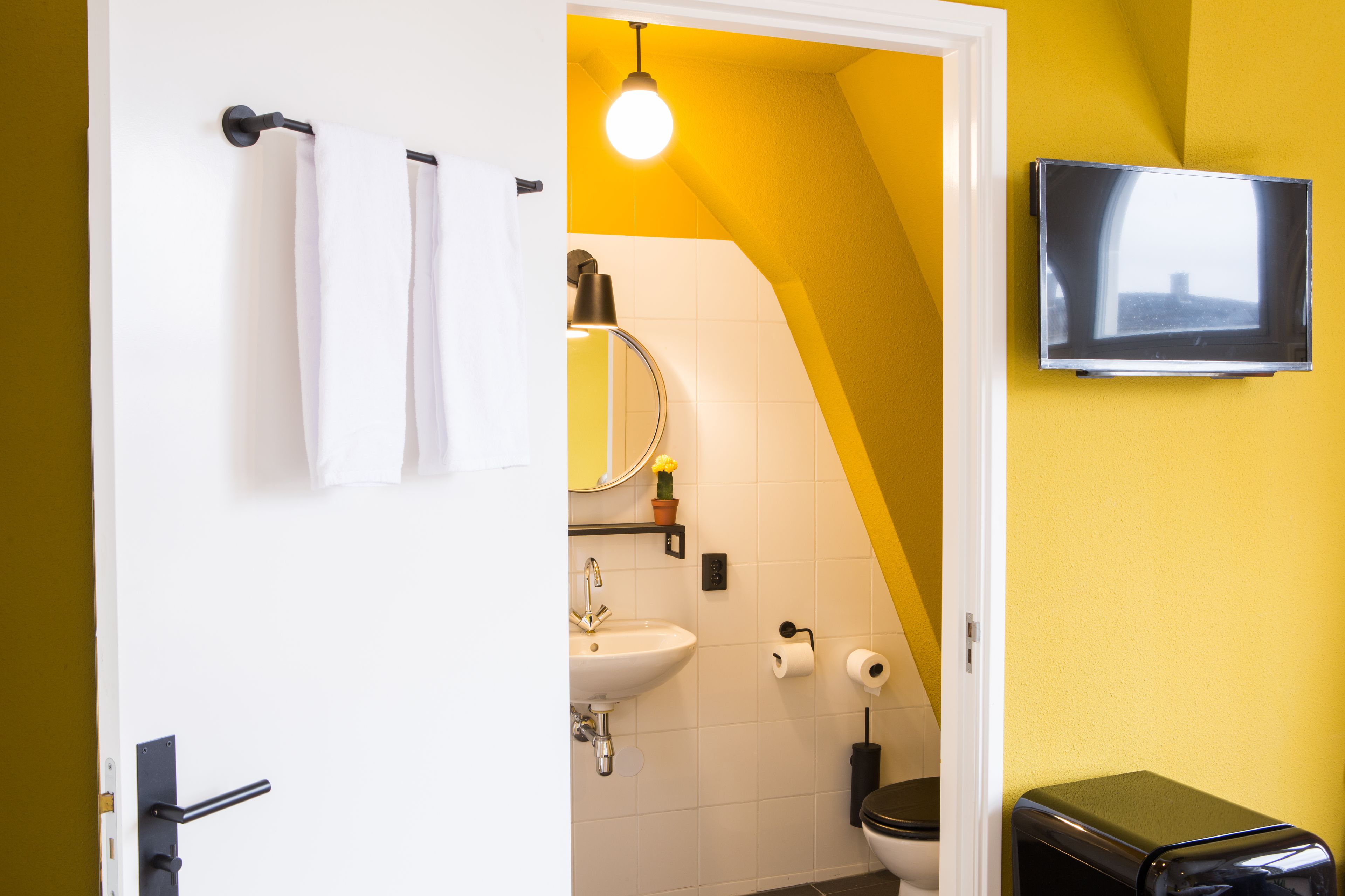 Een badkamer met een witte wastafel, toilet en handdoekhouder.