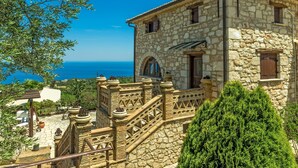 Un edificio in pietra con una scala e vista sul mare.