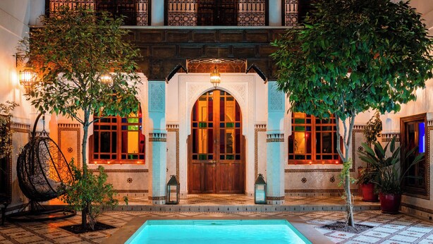 A pool area with a fountain, surrounded by a building with ornate windows and a large wooden door. - Ysalis Riad Restaurant & Spa (Marrakech)