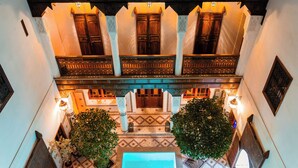 A traditional interior with a central courtyard, wooden balconies, and patterned tiles. - Ysalis Riad Restaurant & Spa (Marrakech)