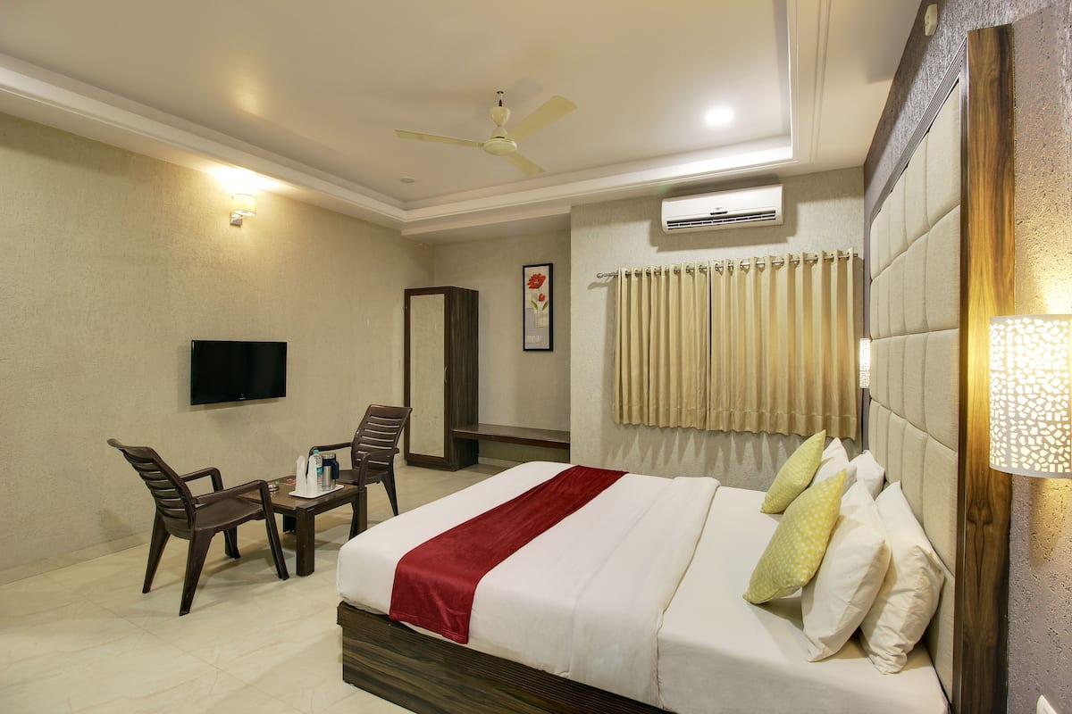 Une chambre d’hôtel équipée d’un lit, d’un bureau, d’une chaise, d’une télévision et d’un appareil de climatisation.