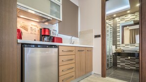 Une cuisine moderne équipée d’un lave-vaisselle, d’une machine à café et de meubles de rangement en bois.