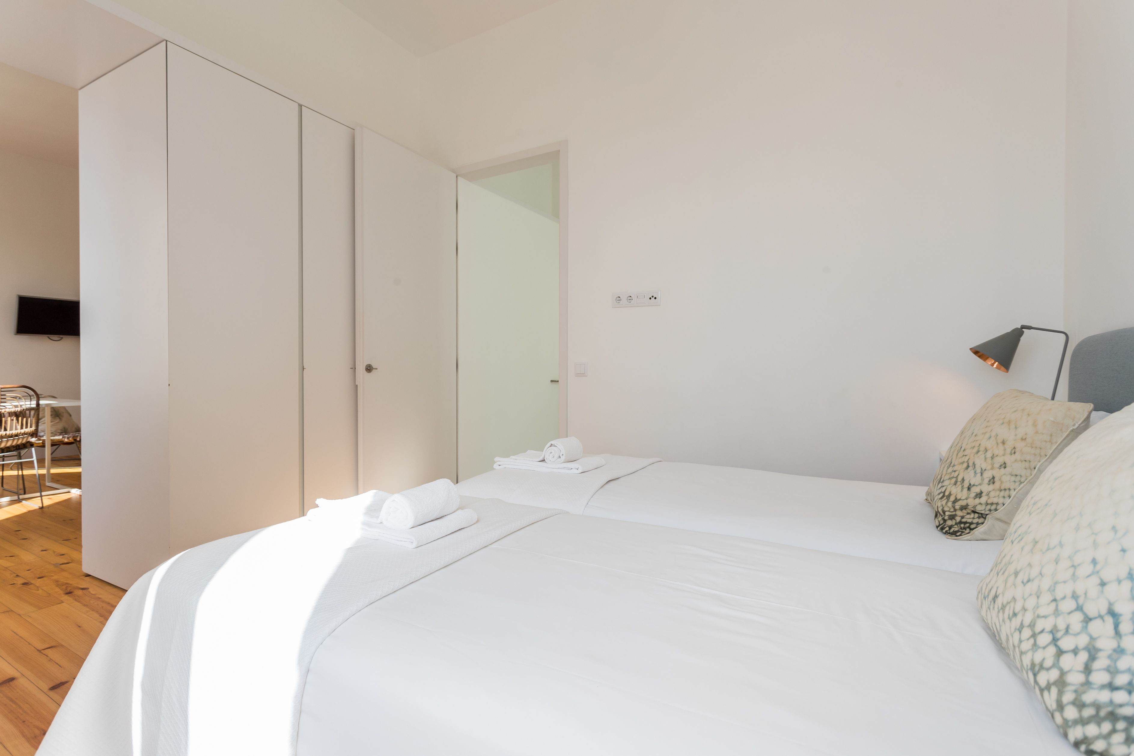 Ein Hotelzimmer mit Bett, Kleiderschrank, Schreibtisch und Stuhl.
