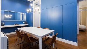 A modern room with a white table and brown chairs, blue walls, and a large wardrobe.