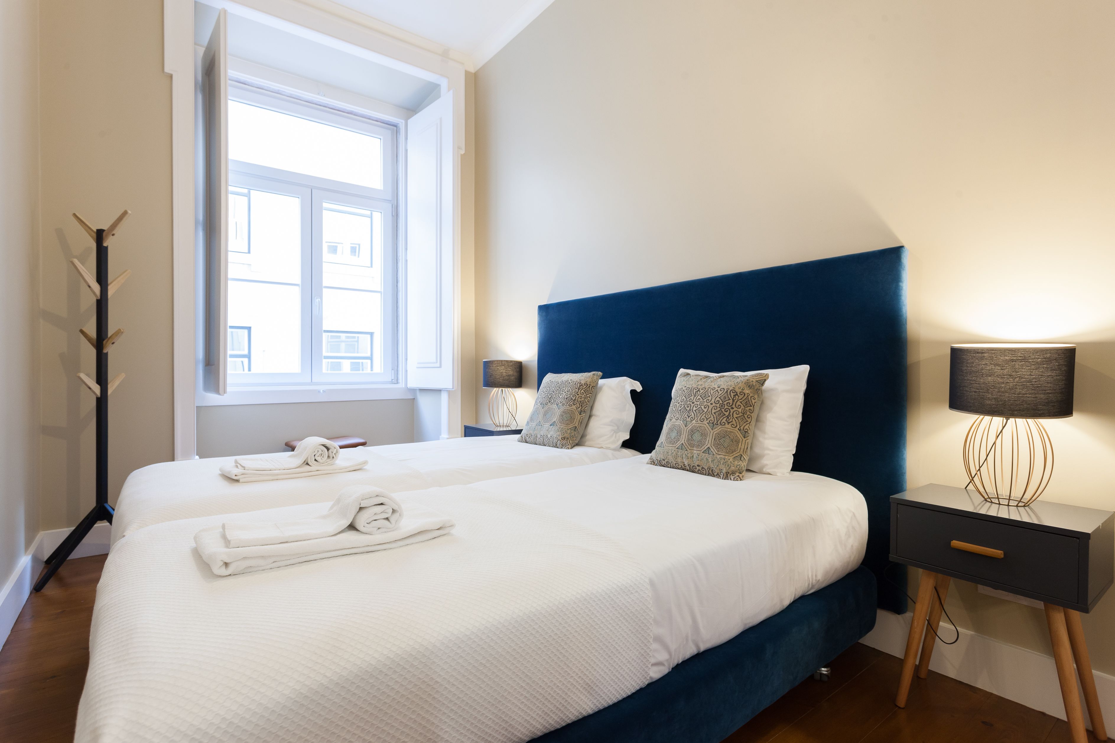 Une chambre d’hôtel avec deux lits, une fenêtre, une lampe et une table de chevet.