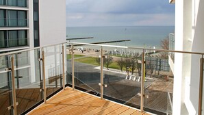 Un balcón con vista al mar y un estacionamiento.