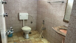Un baño pequeño con inodoro, lavamanos y ducha.