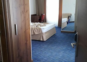 A hotel room with a bed, a chair, a desk, and a mirror. - Miroglu Hotel (Diyarbakir)