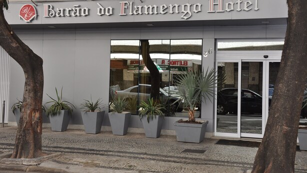 Das Hotel Barão do Flamengo: Außenansicht mit moderner Fassade, großen Glasfenstern und Pflanzen im Vorbereich.