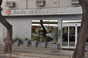 The exterior of Barão do Flamengo Hotel with a modern facade, large glass windows, and potted plants in front. - Hotel Barão do Flamengo - Adult Only (Rio de Janeiro)