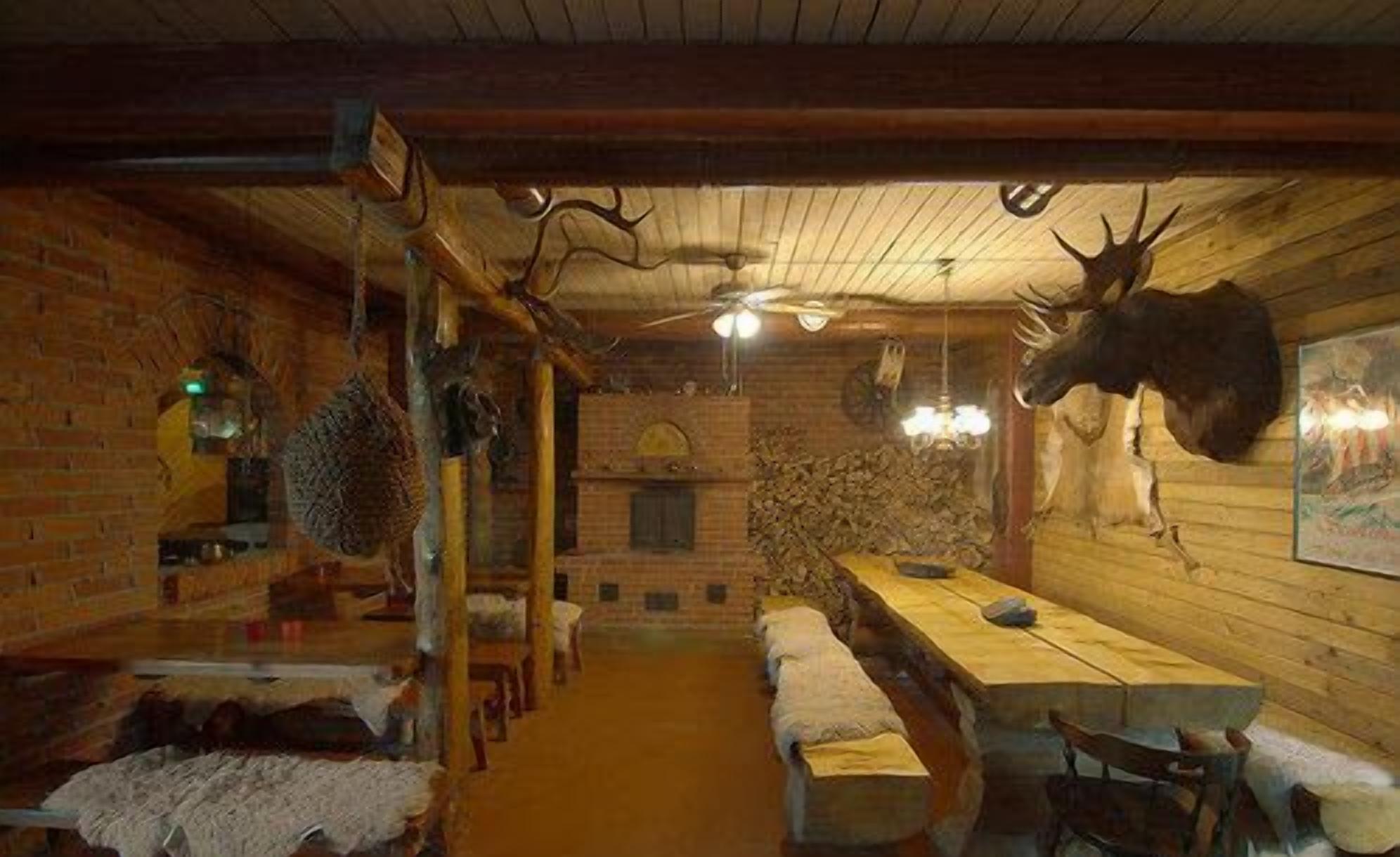 Una habitación rústica con una larga mesa de madera, bancos y un ventilador de techo.