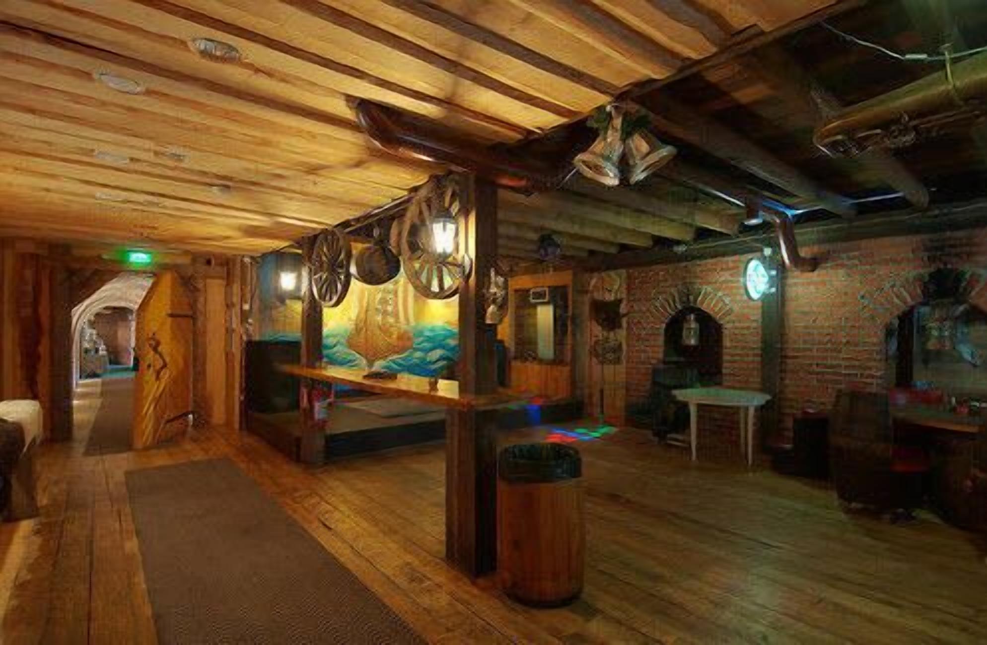 A rustic interior with wooden beams, a brick wall, and a wooden floor.