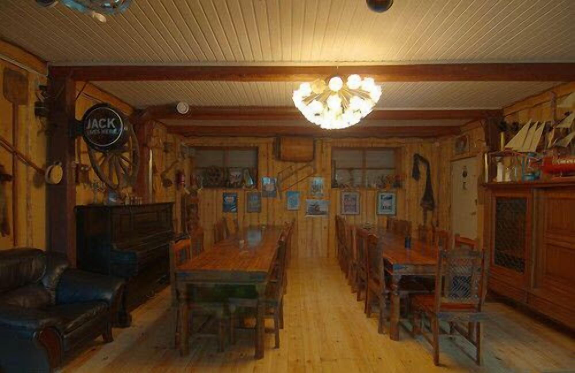 Un comedor de madera con candelabro, un sofá de cuero y un cartel que dice "JACK'S MENUS".