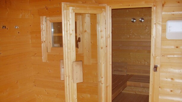 A wooden cabin with a door open, revealing a wooden floor and a small window. - Sommette (Somme-Leuze)