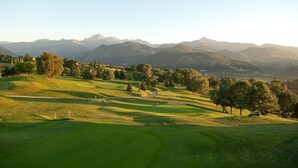 Un campo de golf con vistas despejadas a montañas lejanas.