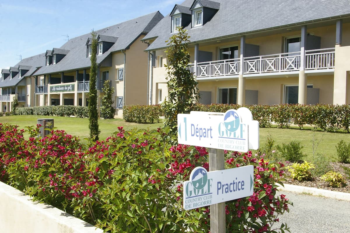 A building with signs indicating 'Départ' and 'Pratique' for a country club.