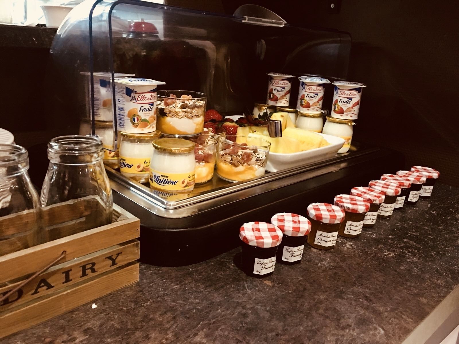 A breakfast buffet with various dairy products and desserts.