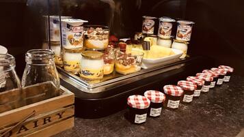 A breakfast buffet with various dairy products and desserts.