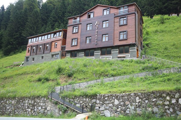 Un edificio de dos pisos con cimientos de piedra, varias ventanas y un letrero que dice