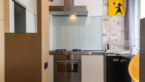 Una cocina moderna con electrodomésticos de acero inoxidable, salpicadero de azulejos y pared de ladrillo.