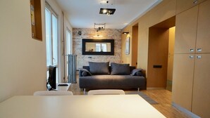 Una sala de estar moderna con sofá, mesa de comedor y área de cocina.
