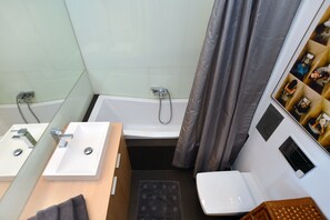 Un baño con bañera, dos lavamanos, inodoro y ducha.