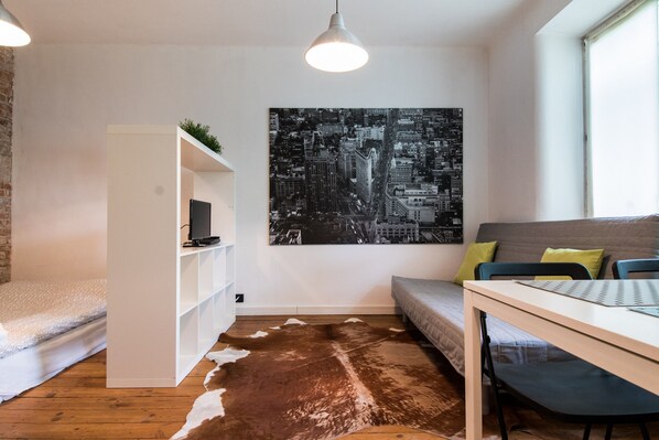 Design studio, 1 tweepersoonsbed met slaapbank | Woonruimte | Een flatscreentelevisie