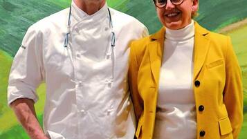 Two people standing in front of a painting.