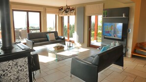 Un salon moderne avec une cheminée, un canapé, une table basse et un téléviseur.