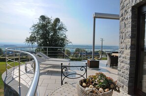 A rooftop terrace with a curved metal railing, a bench, and a potted plant. - La Colline (Somme-Leuze)