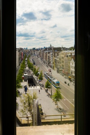 A city street with tram lines, buildings, and pedestrians.