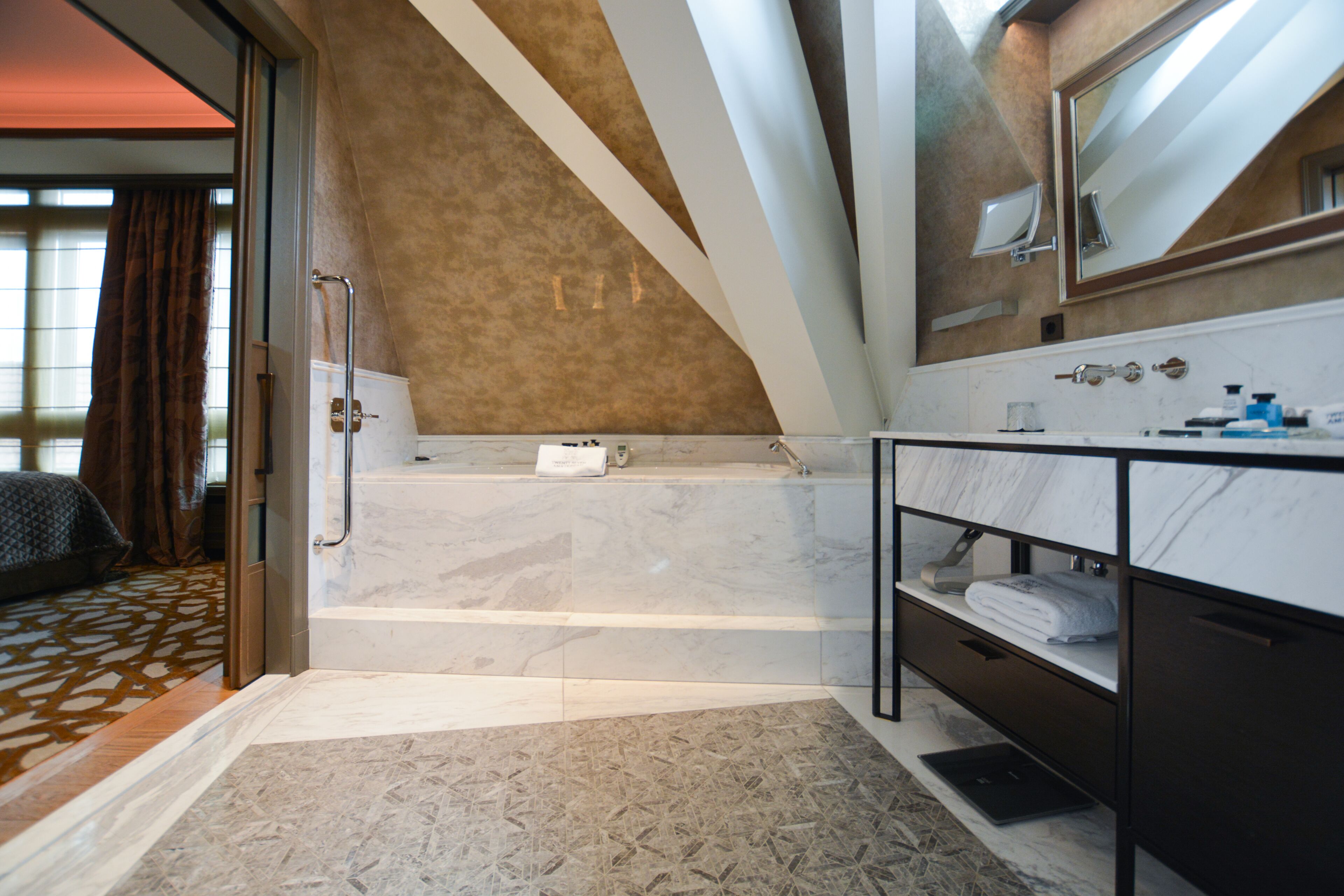 A modern bathroom with a bathtub, a vanity with a mirror, and a shower area.