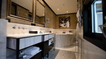 Ein modernes Badezimmer mit einem großen Spiegel, zwei Waschbecken, einer Badewanne und einer Dusche.