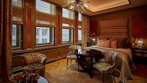 A luxurious bedroom with a large bed, a chandelier, and a view of the city through large windows. - Hotel TwentySeven (Amsterdam)
